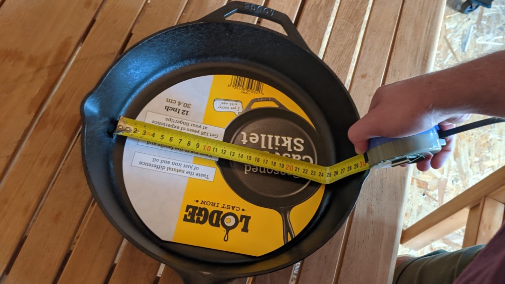 Aká je hrúbka dna pri zaoblenej liatinovej panvici Lodge 30 cm?