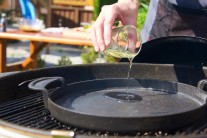 Do grilu Weber One-Touch sme použili ťažkú liatinovú panvicu BBQ. Na panvicu nalejeme trochu oleja a necháme riadne prehriať. Skúšku teploty vykonáme vhodením jedného kúsku do oleja na panvici. Ak sa začne hneď smažiť, je olej dosť rozohriaty a my môžeme pridať ostatné naložené mäso.