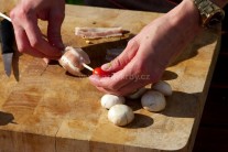 Pripravíme si kovové ihly alebo špajdle a môžeme začať s prípravou špízov. Napichujeme striedavo hlavičku šampiňónu obalenú v plátku anglickej slaniny a cherry paradajkami. Takto postupujeme, kým nemáme ihlu alebo špajdľu plnú.